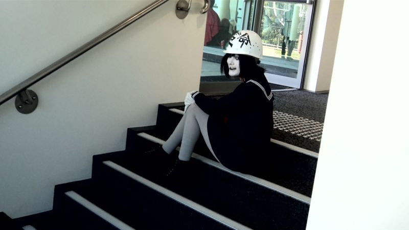 Grinning while sitting on the stairs.